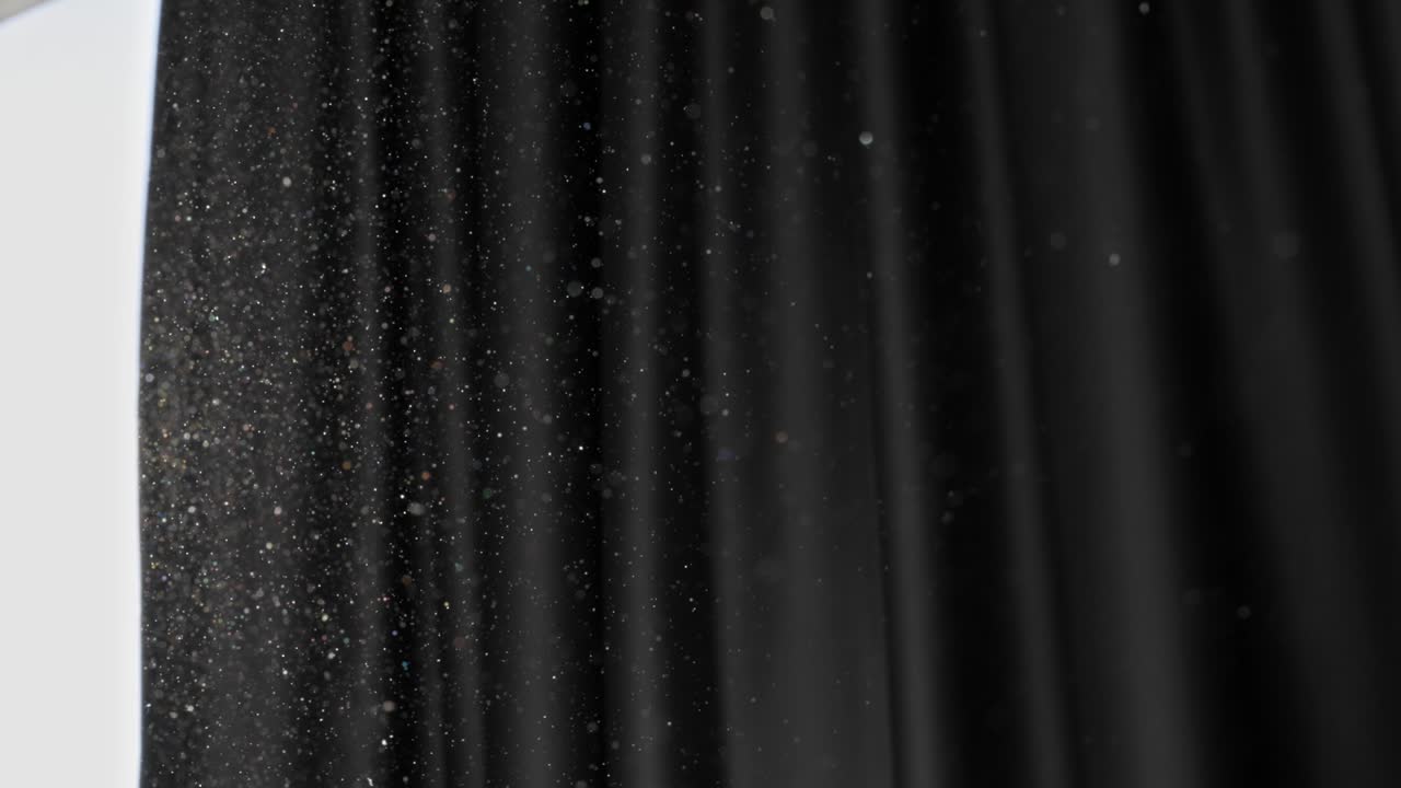 Slow motion shot of floating dust particles in the air. Dust in the room with dark background. Air pollution, allergy, difficulty breathing concept. UHD, high quality