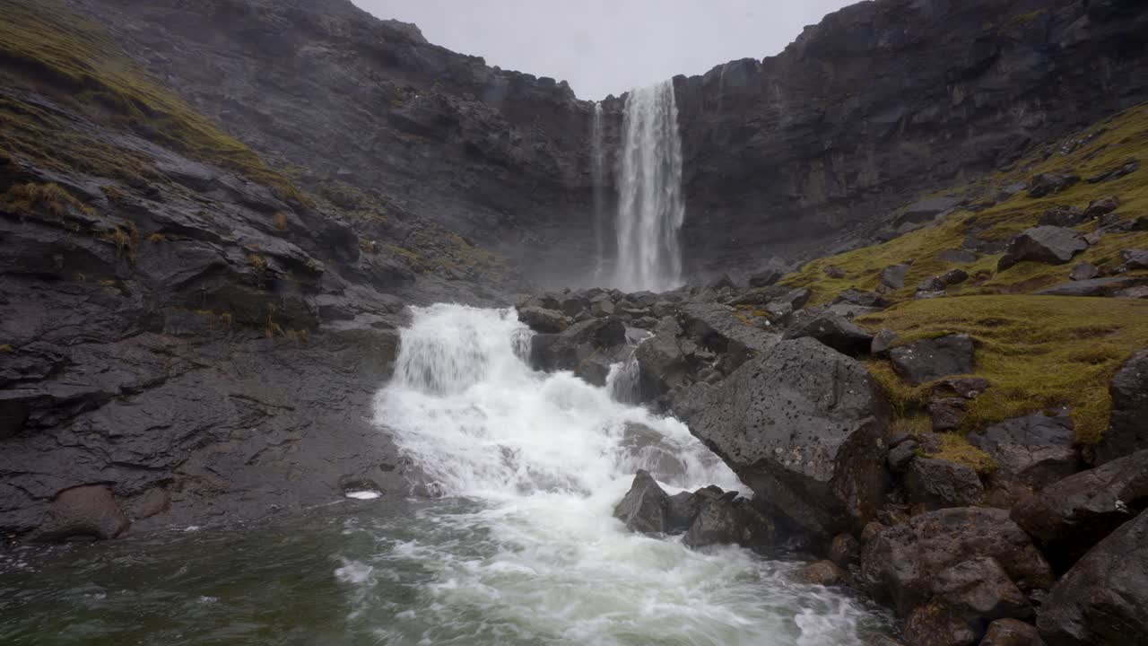 toma estática en ángulo bajo de la famosa cascada fossarfoss en la isla streymoy, con descensos de agua que fluyen