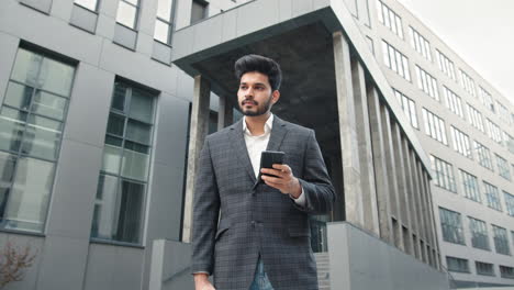 businessman using smartphone outside office building