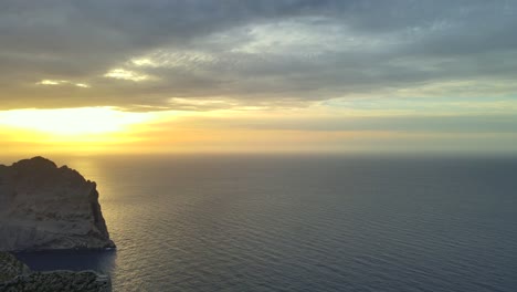 experience a breathtaking sunset over the tranquil mediterranean sea near pollensa, mallorca. the vibrant colors and serene water create a peaceful atmosphere, ideal for relaxation.