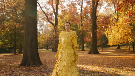 woman in a yellow leaf dress in an autumn forest