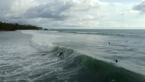los surfistas se enfrentan a las olas bajo un cielo de mal humor.
