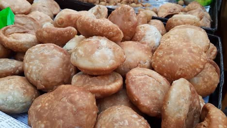 primer plano de la comida callejera india samosa, kachori y pakora en un carro en una concurrida zona de mercado