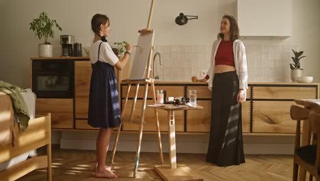 daughter painting with mother watching