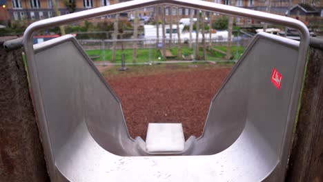 children view from the top of a metallic slide in a playground, symbol of bravery, courage, thrill, adventure, stress, and excitement