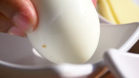 a boiled egg in a white bowl on a wooden table