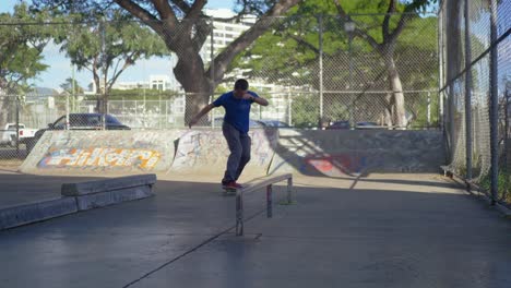 man skateboards under a bridge and then does a kickflip on to the rail