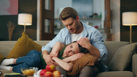 gentle man regretting woman crying at sofa. calm guy comforting beloved lady