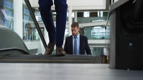 businessman on the escalator in modern office building