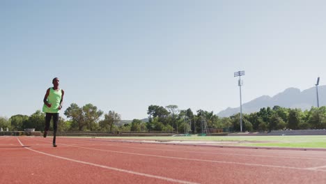 disabled mixed race man with prosthetic legs running on race track