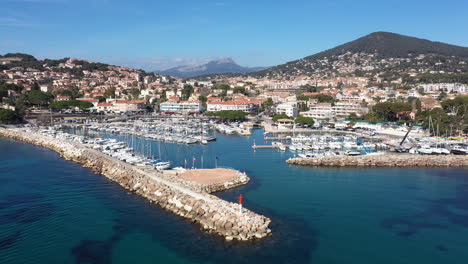 aerial back traveling over carqueiranne harbor with mountains in background