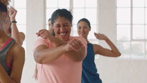 Feliz-Mujer-Con-Sobrepeso-Bailando-Grupo-De-Personas-Sanas-Disfrutando-Del-Entrenamiento-Practicando-Movimientos-De-Baile-Coreográficos-Divirtiéndose-En-El-Gimnasio