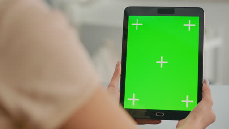 acercamiento de las manos de la mujer sosteniendo una tableta con una pantalla verde simulada