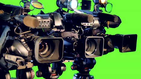 row professional video cameras on tripods.