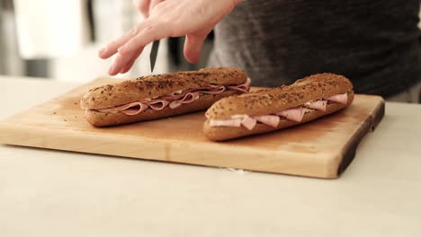 Maquillaje-Caucásico-Terminando-Una-Baguette-Marrón-Casera-Rellena-Con-Fiambres-Y-Queso.