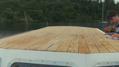 limpiando el techo lijado de un barco de madera con tela y diluyentes de pintura