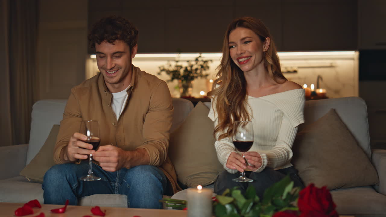 Smiling pair spending evening in romantic home atmosphere. Shying two people