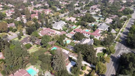 Aerial-view-overlooking-city-of-San-Marino-houses-and-pools,-on-a-sunny-clear-day