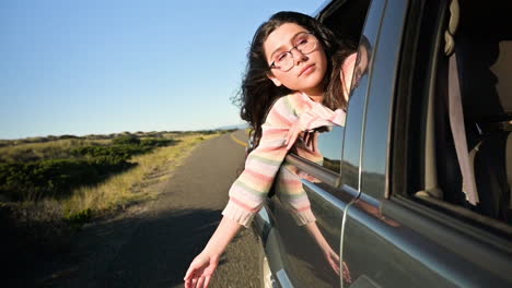 girl hanging out of car window in slow motion