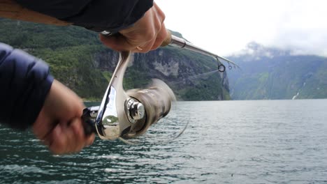 mujer pescando en una caña de pescar girando en noruega.