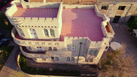 Aerial-view-revealing-the-Sermini-Castle-in-the-Providencia-sector,-pedestrians-passing-by-in-a-quiet-and-nostalgic-sunset,-ramparts-and-fortresses