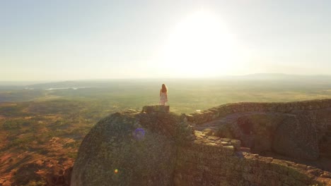 woman on ancient clifftop at sunrise/sunset