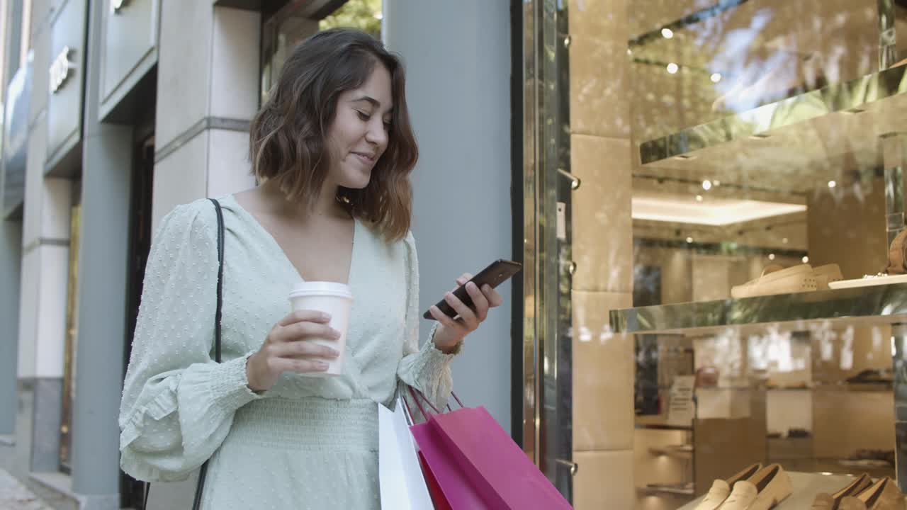 mujer latina sosteniendo un teléfono inteligente, leyendo chat, sonriendo