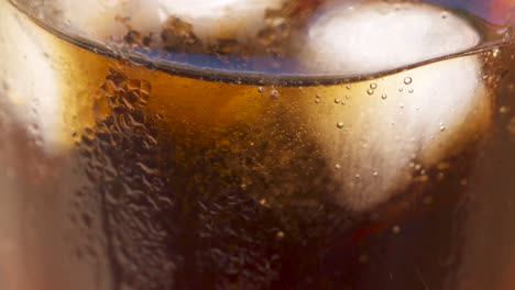 looking through a glass as soda is sucked through a straw