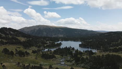 Aerial-view-approaching-to-a-big-lake-surrounded-by-trees