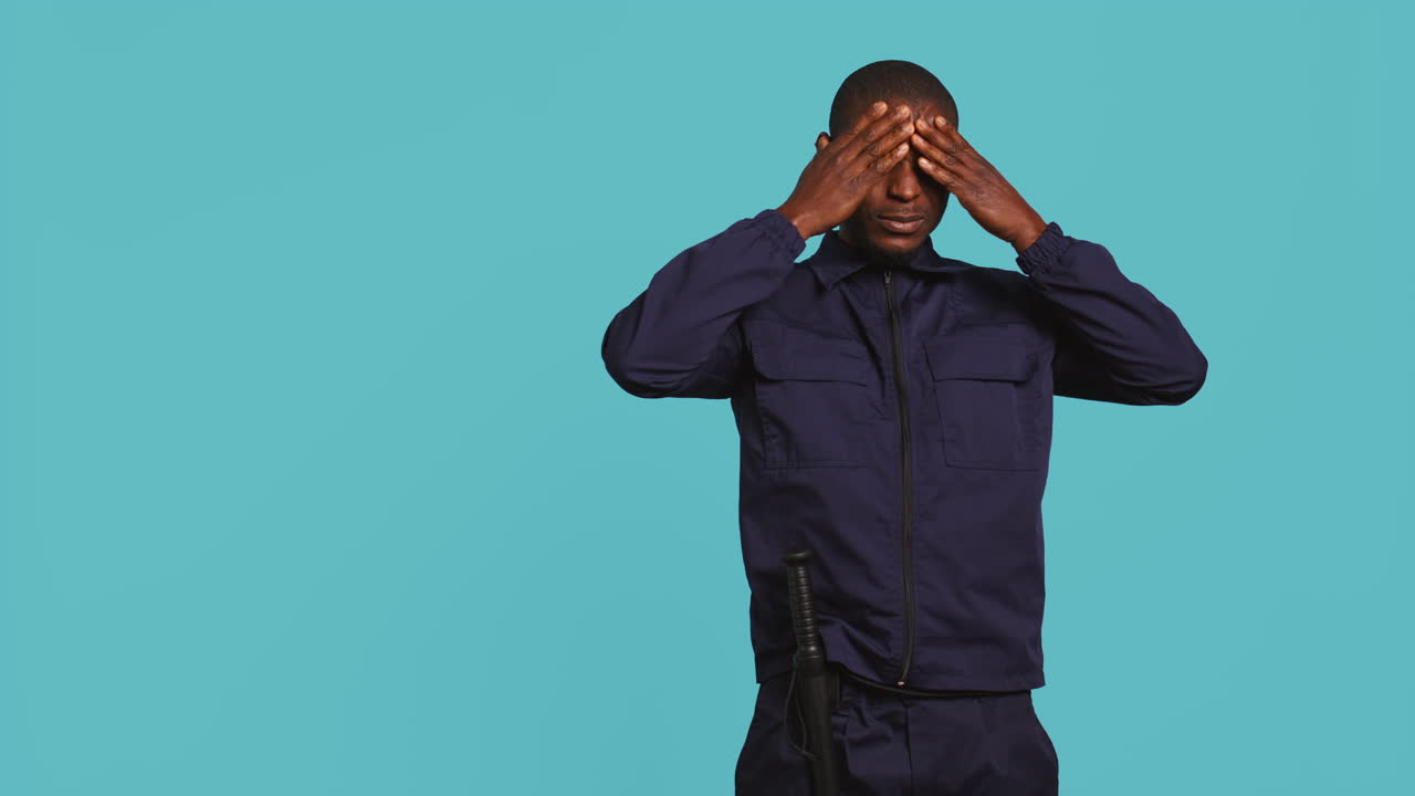 Portrait of tired security guard suffering from painful headache