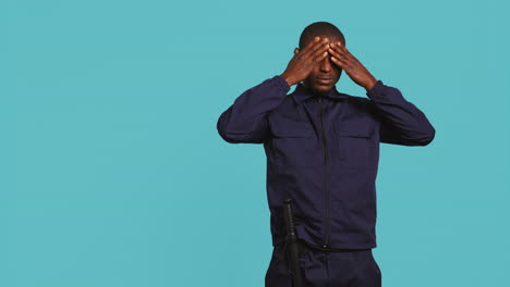 portrait of tired security guard suffering from painful headache