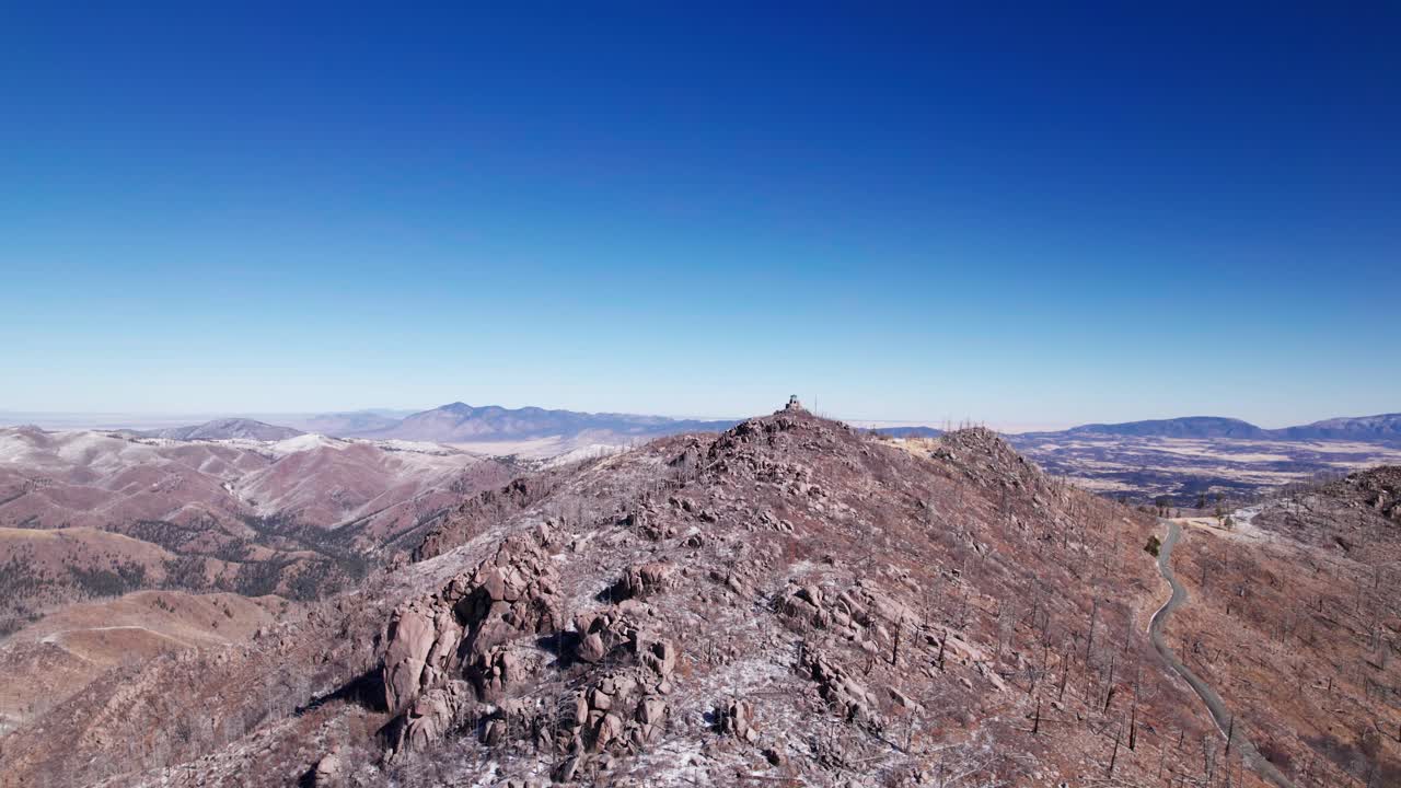 vista aérea del avión no tripulado orbitando un pico de montaña rocoso y nevado por encima de todo