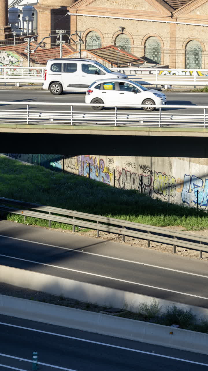 Cars on a highway overpass with graffiti covered walls