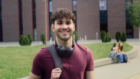 portrait of male university student standing outside the university campus