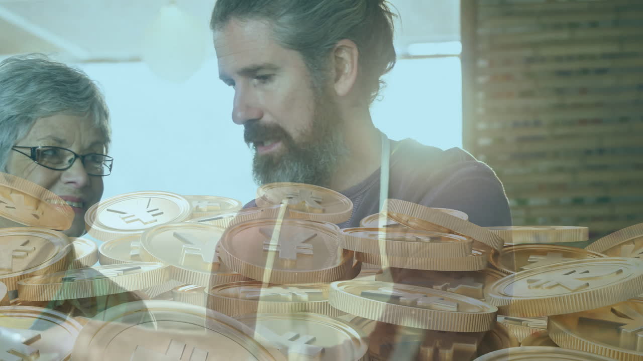 Examining digital currency coins, elderly woman and man in bright room