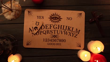 ouija board with candles and other occult items