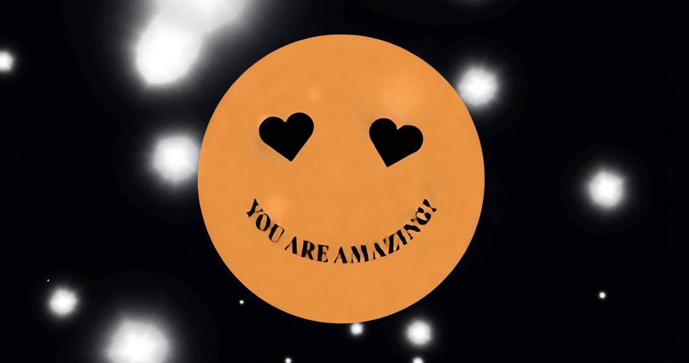 Au démarrage, un visage emoji orange animant du texte, inclinant des yeux en forme de cœur, avec des lumières bokeh flottantes, améliorant l'ambiance.