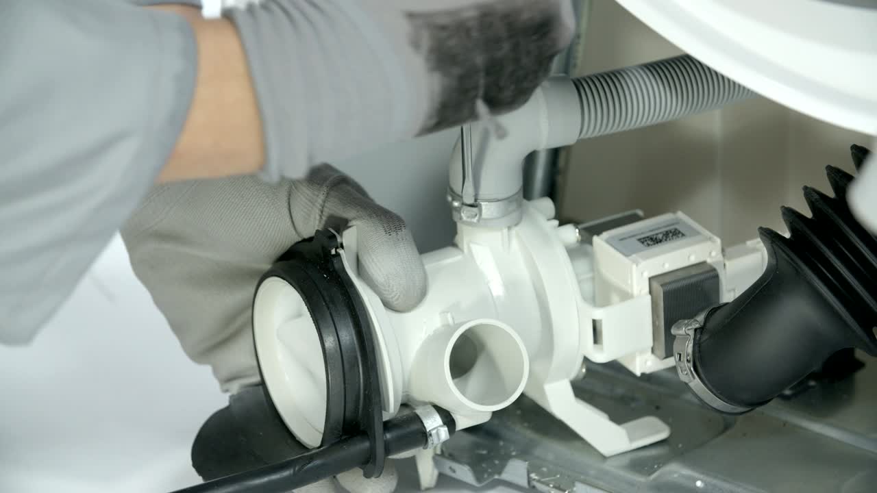 수리 직원이 배수 프에서 호스를 꺼내고 있습니다.