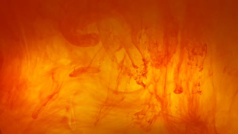 ink swirls creating a fire burning effect with orange and red dye moving in the water, beautiful background color footage