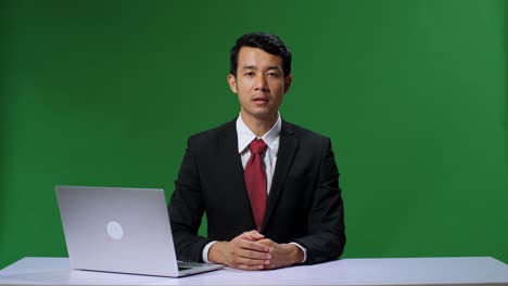 Green Screen Background: Live News Studio With Professional Asian Male Anchor Reporting On The Events Of The Day. Television Channel Newsroom Concept. Chroma Key Template Background