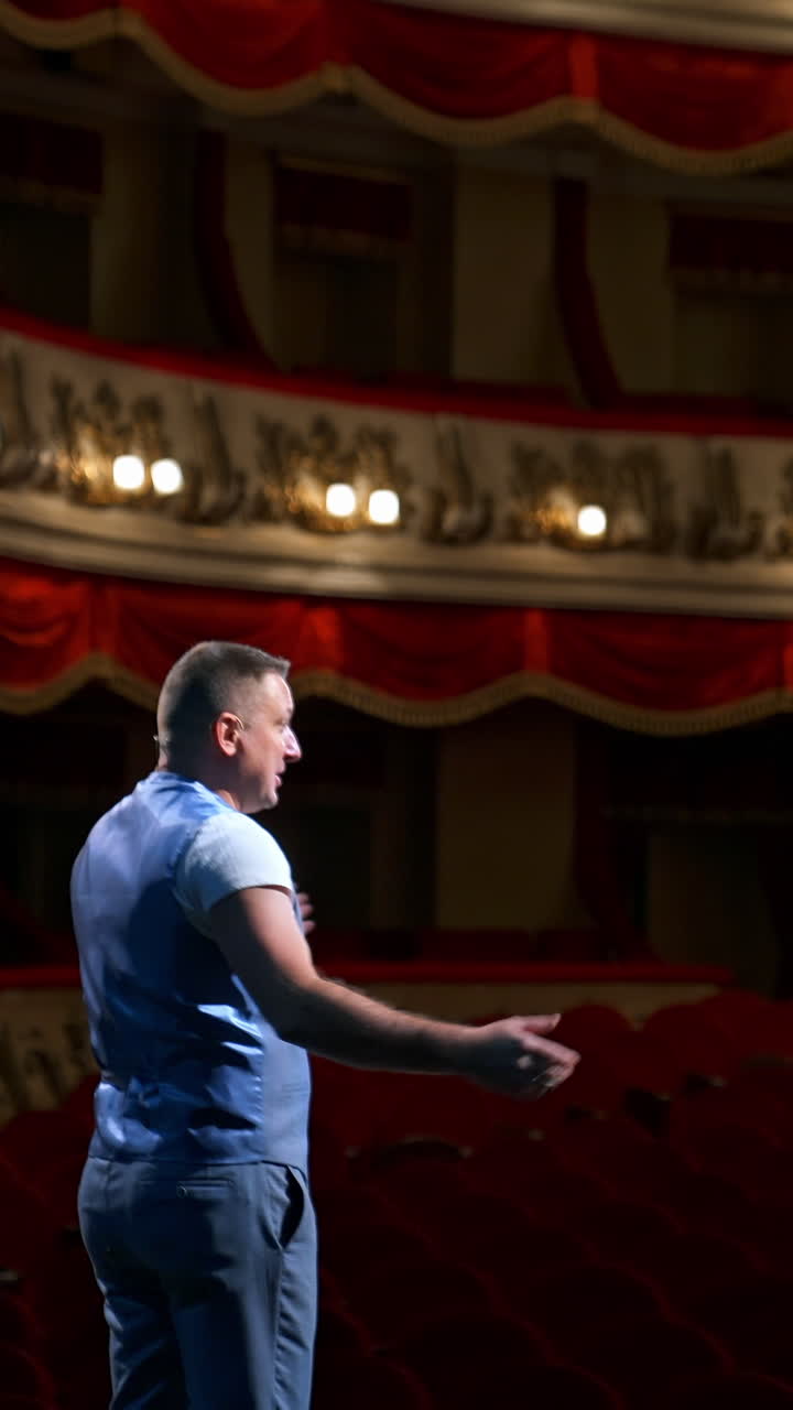 Rehearsal before the performance. Actor man is talking to the empty auditorium during pandemic in the world. Speaker talking in the theater with no people. Vertical video