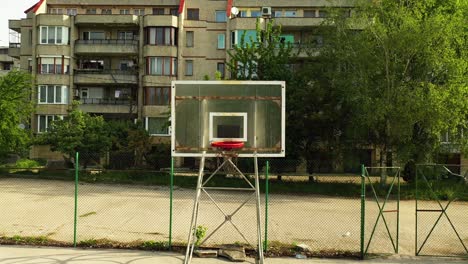 backward aerial footage of empty basketball field in the neighborhood