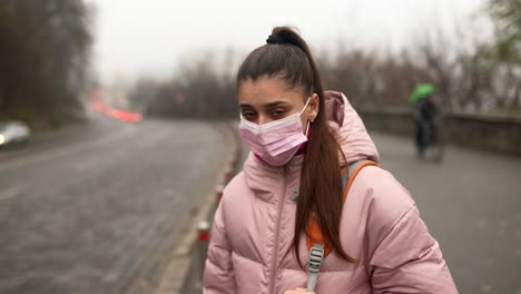 woman wearing mask in a city with fog and traffic