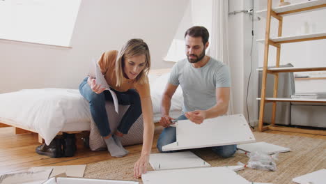 pareja en un nuevo hogar armando muebles de autoensamblaje