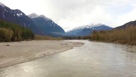 Flying-low-over-a-pristine-river-in-a-majestic-mountain-valley,-British-Columbia,-Canada