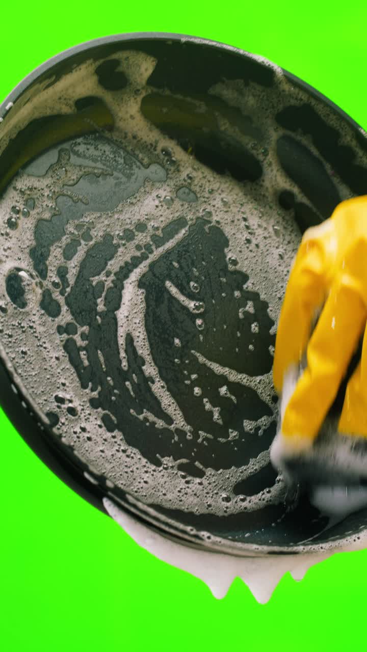Hand in Yellow Glove Washing Frying Pan with Soap Suds