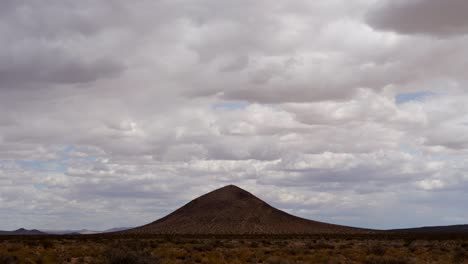 nuvens se movem no céu acima de uma montanha vulcânica no deserto de mojave - lapso de tempo