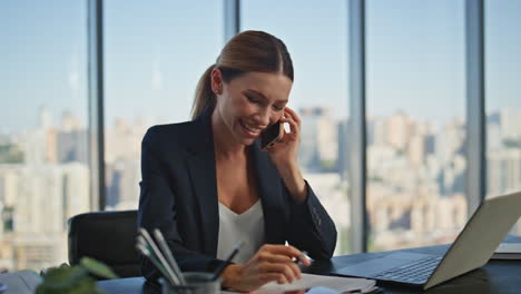 hr manager speaking mobile phone in office making notes. smiling employee call