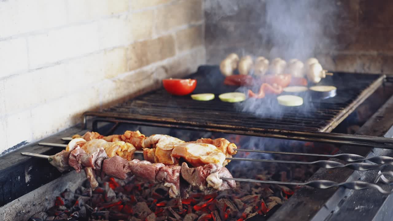 Grilling food. Barbecue. Hot grill with charcoals on the restaurant kitchen. Smoking grill frying meat and vegetables. Hand of a chef turning over grilled vegetables.