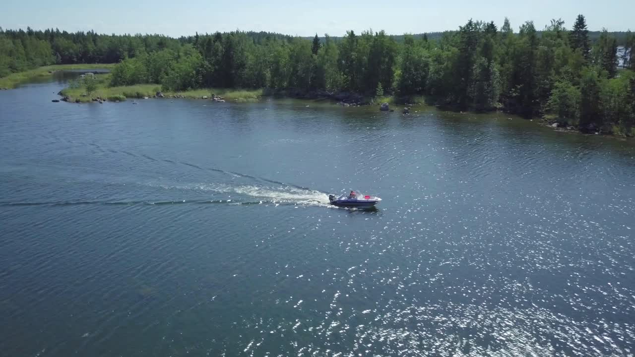 Boating family cruising through a river with forest in background Kvarken Vaasa Finland